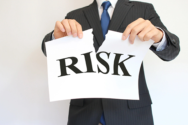 RISKと書かれた紙を破いているビジネスマン