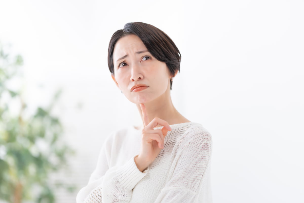 インプラント治療は痛いのか考える女性