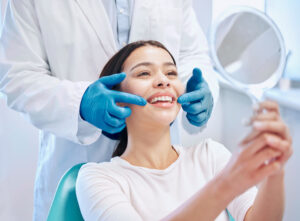 鏡でホワイトニング後の歯を確認する女性