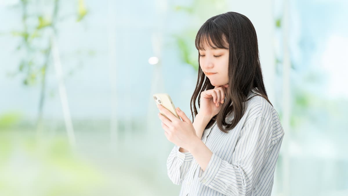 銀歯を白くする際に保険適用できるか調べる女性