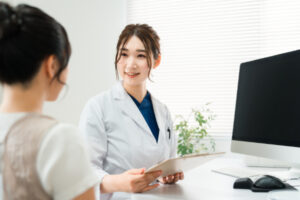 横向きに生えた親知らずの相談をする女性と歯科医師