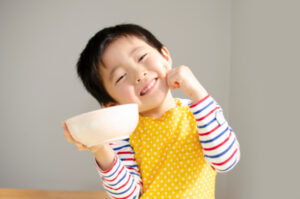 時間を守って食事をする笑顔の男の子