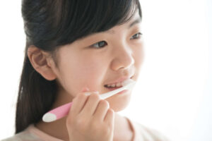インビザライン・ファーストの治療中に虫歯にならないように丁寧に歯みがきをする女の子