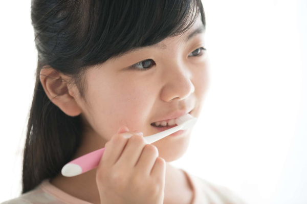 インビザライン・ファーストの治療中に虫歯にならないように丁寧に歯みがきをする女の子