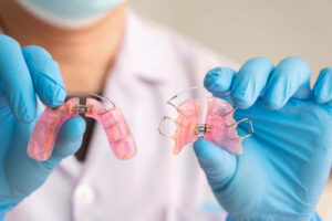 床矯正の器具を手に持った歯科医