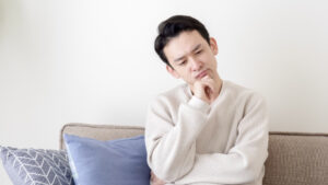 インプラント治療に保険が使えるのか疑問に思う男性
