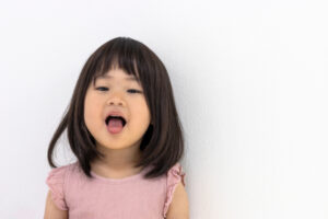 口呼吸を治すため舌の運動をする子ども