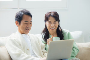 2人でパソコンを見るリラックスした表情の夫婦