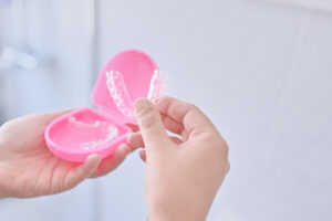 マウスピースをケースから取り出す女性の手元