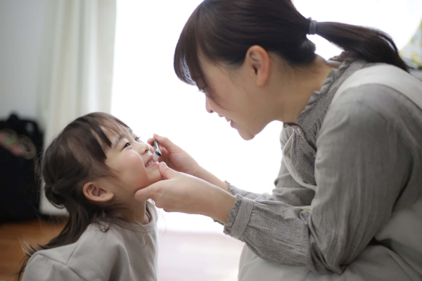 歯肉炎の予防で歯の仕上げみがきをしている母親