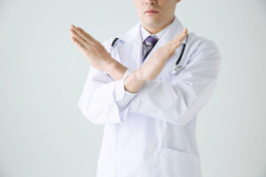 両手でバツマークをしている