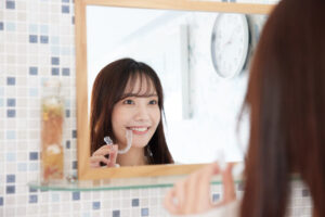 時計を確認しマウスピースを装着する女性