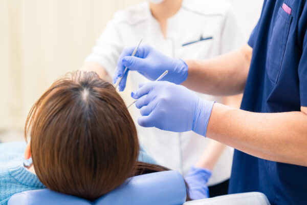 歯科医師が女性の歯を定期検診している