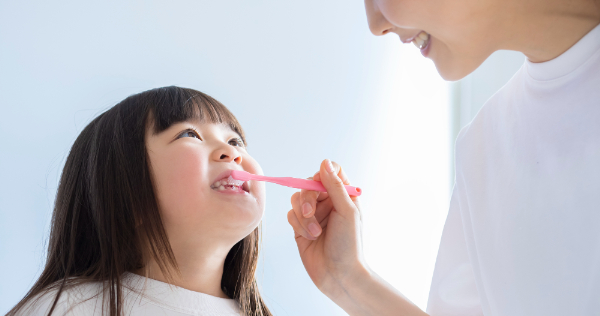 仕上げ磨きをしてもらう女の子