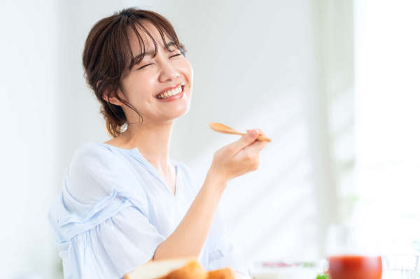 顎関節症を治療して痛みが取れて快適に食事をする女性