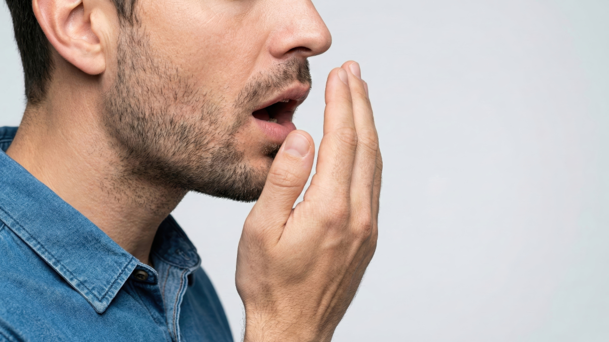 口臭のセルフチェックをする男性