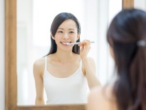 ワイヤー矯正治療中に歯磨きをしている女性