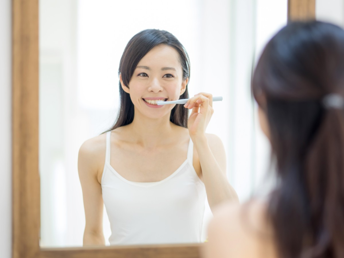 ワイヤー矯正治療中に歯磨きをしている女性