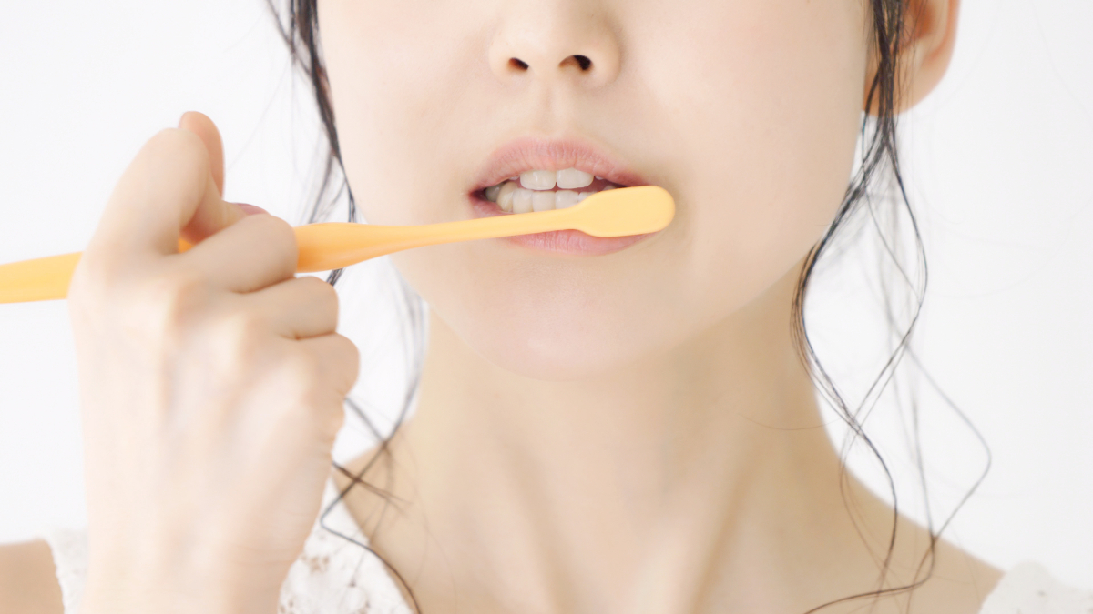 口臭の予防として歯磨きをする女性