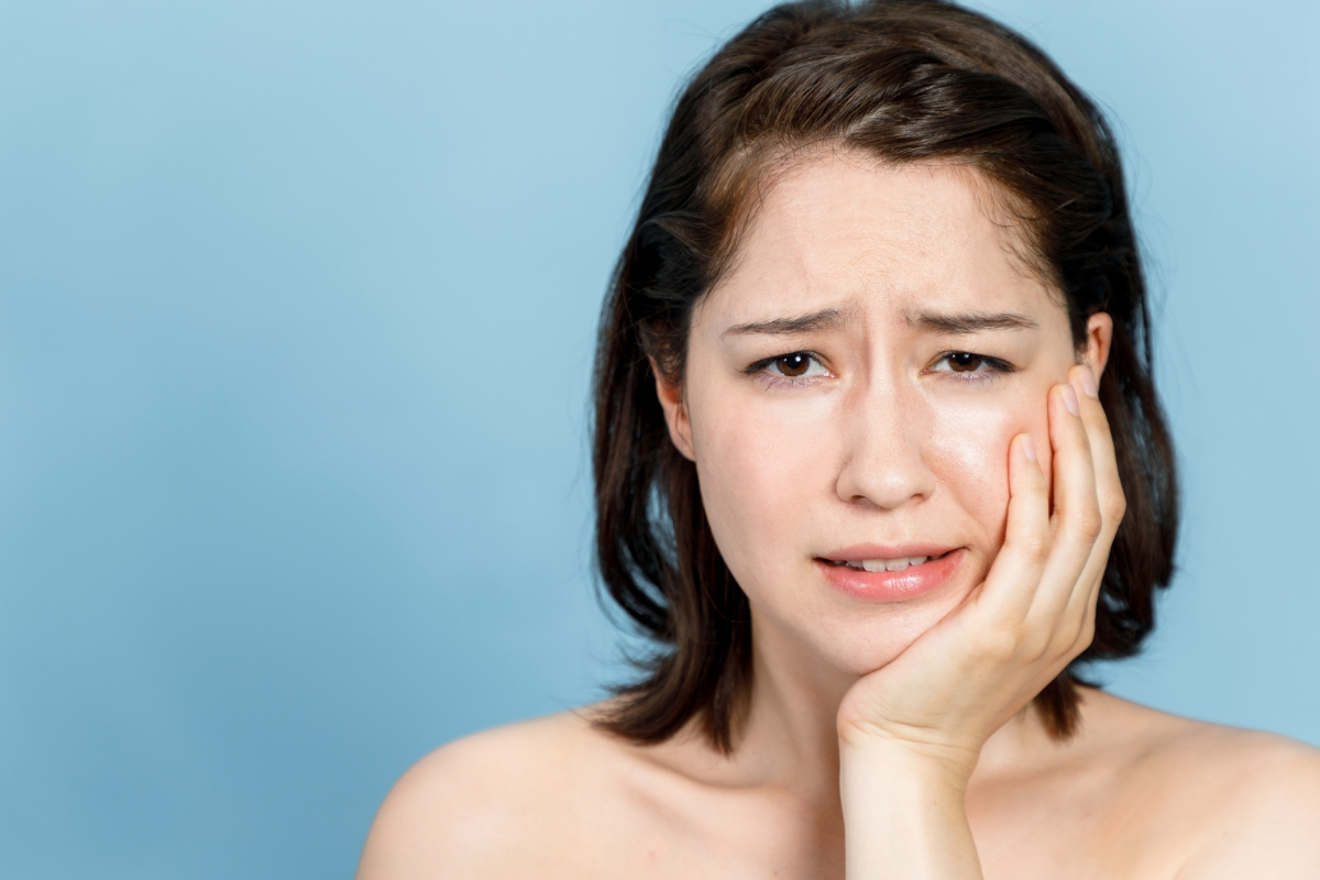 銀歯の下が虫歯になったときに見られる症状として歯がしみている女性