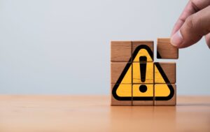 ビックリマークの書かれたブロックを組み立てている手