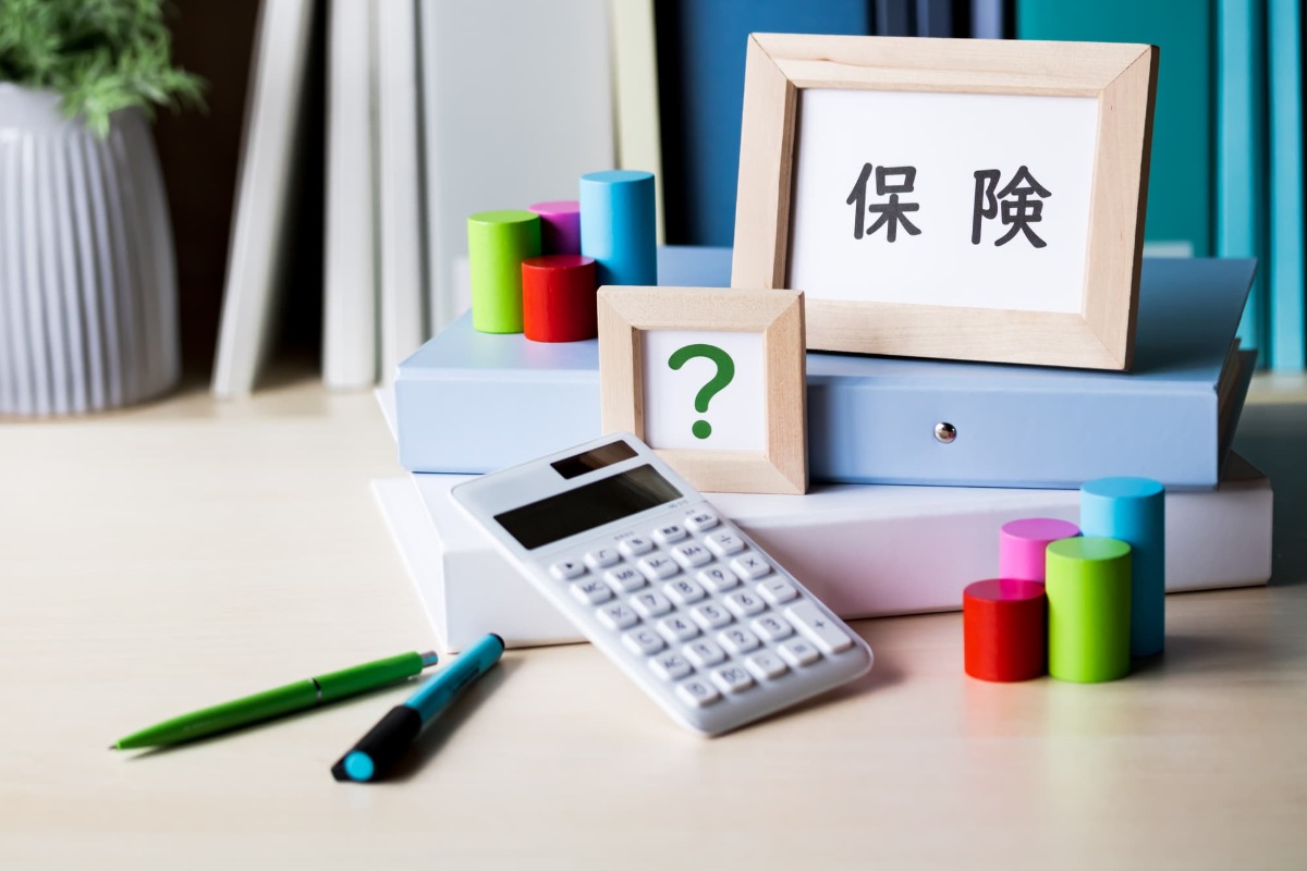 保険の文字とハテナマークの入った額縁と計算機