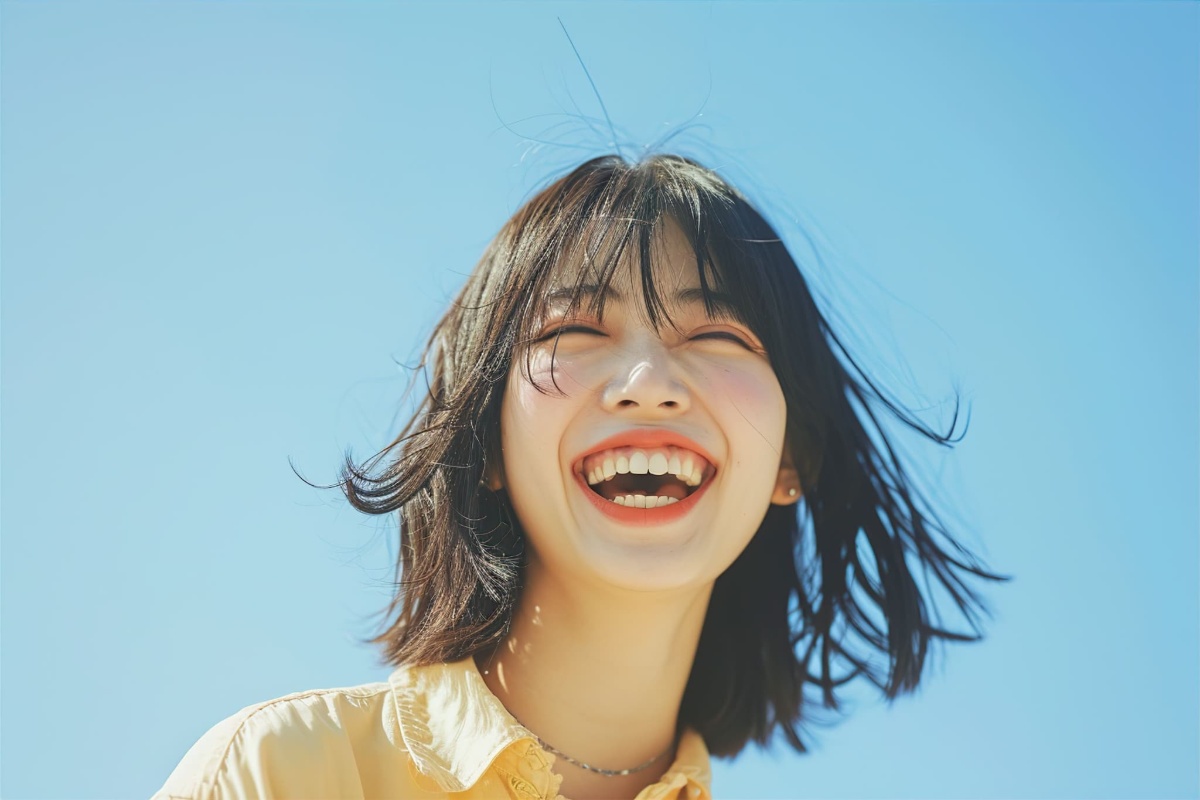 青空の下で楽しそうに笑っている女性