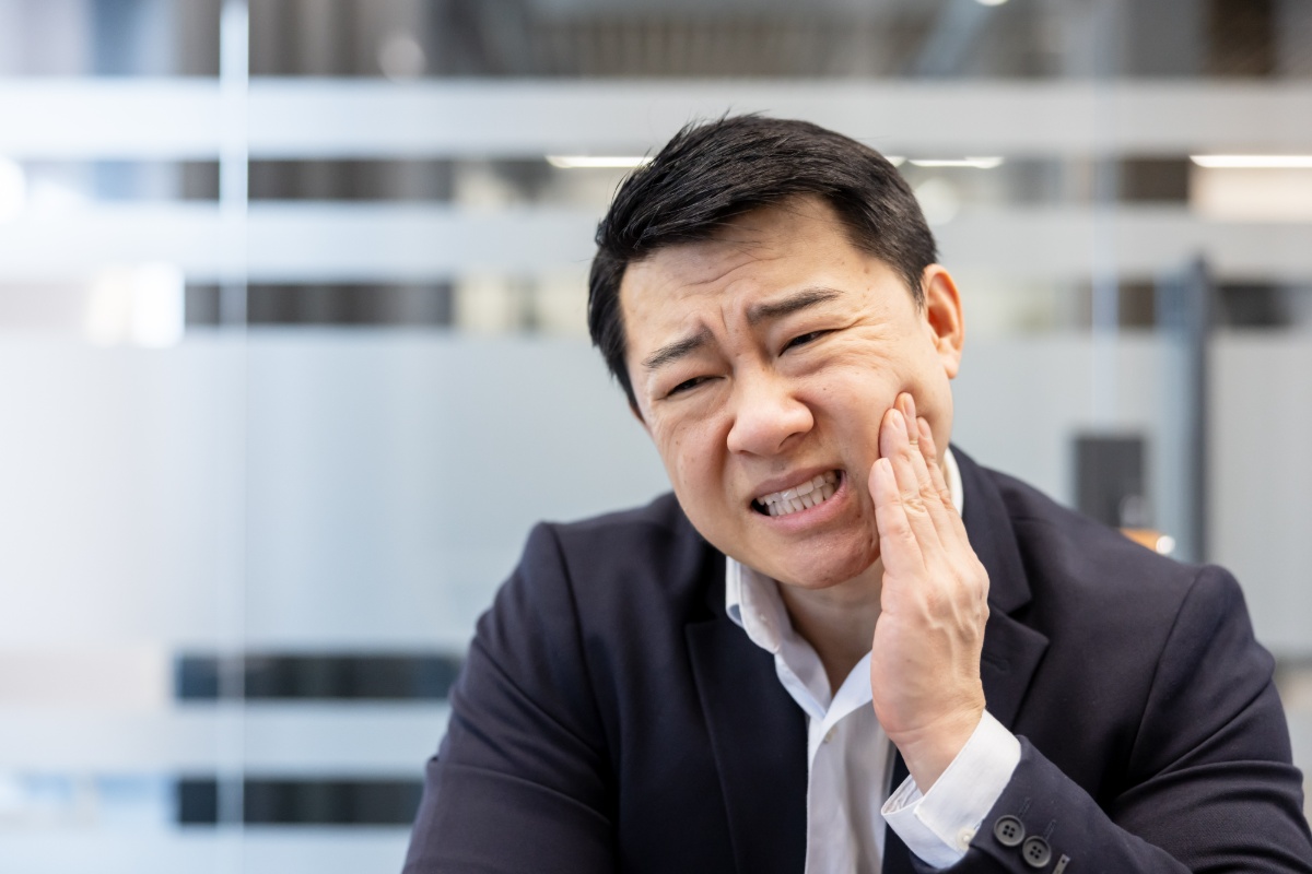 歯の痛みに顔をゆがめる男性